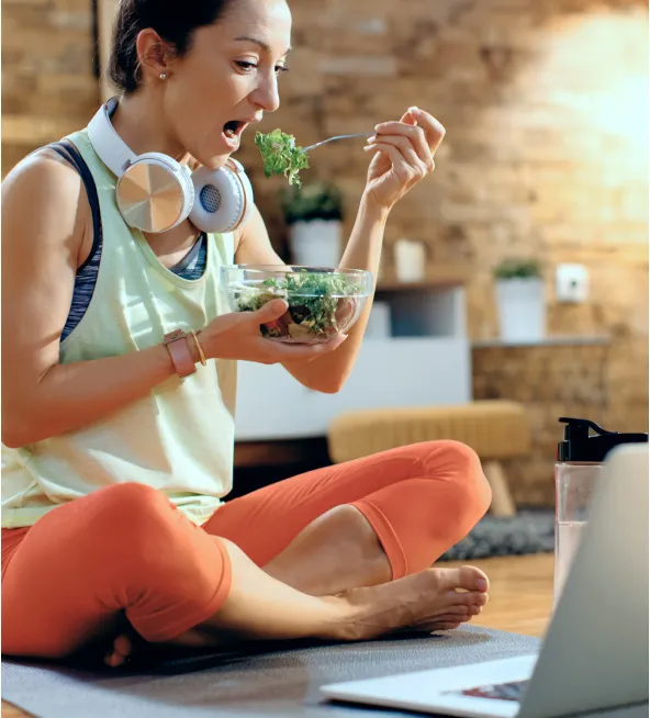 Woman eating a healthy salad while following the program